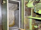 a green machine that is sitting inside of a building