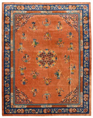 un tapis orange avec une bordure bleue et un motif floral