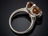 a close up of a ring with a brown stone on a black surface