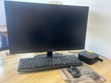 a computer monitor sitting on top of a wooden desk next to a mouse and keyboard