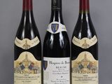 three bottles of red wine are lined up on a table