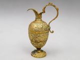 an ornate gold vase with a bird on top of it