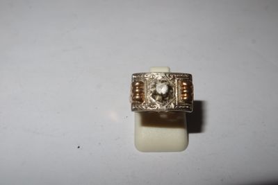 a close up of a ring with a diamond in it on a white surface