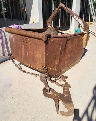 a rusted metal container with a chain attached to it