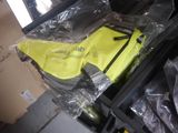 a suitcase with a yellow vest and a pair of shoes in it