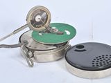 une casserole en argent avec un couvercle vert et un couvercle noir