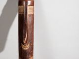 an old wooden stick with a design on it sitting on top of a table