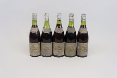 quatre bouteilles de vin sont alignées sur une surface blanche