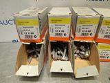 four boxes of screws are stacked on top of each other