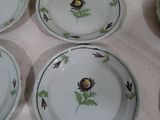 many plates with flowers on them on a table