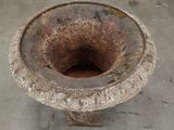 an old urn sitting on the concrete floor