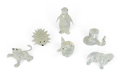 un ensemble de figurines d'animaux en verre posées sur une surface blanche