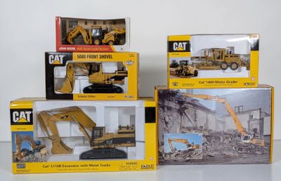 three boxed boxes of construction toys including a cat excavator, a bulldozer, and a bulldozer