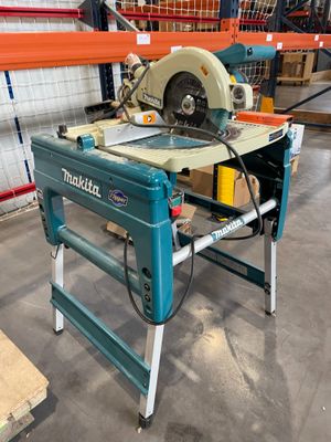 une scie circulaire à table posée sur un support dans un entrepôt