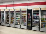 a row of refrigerators in a store filled with drinks