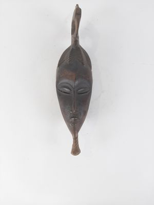 an image of a wooden mask hanging on a wall