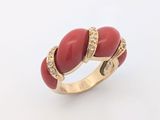 l'image d'une bague rouge et dorée sur un fond blanc
