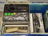 a metal case with tools inside of it on the floor