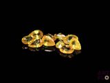 yellow sapphires on a black surface with reflection