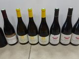 six bottles of wine lined up in a row on a tiled floor
