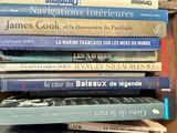 many books stacked on top of each other on a shelf