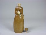 a figurine of a woman holding a bottle of wine