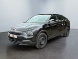 une voiture noire garée dans une pièce au sol noir