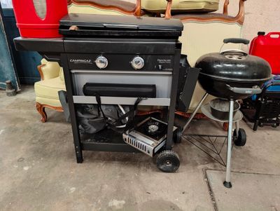 un barbecue et une chaise dans un garage, parmi d'autres objets