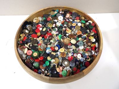 a wooden bowl filled with lots of different types of buttons