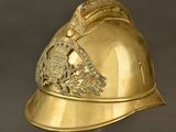 an antique gold helmet with a crest on the side of it