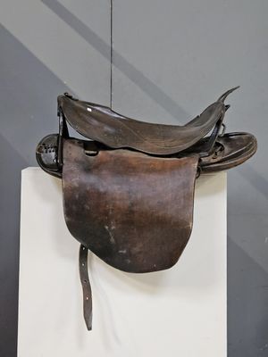 une selle de cheval exposée sur un socle blanc