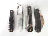 four different types of knives are lined up on a white surface