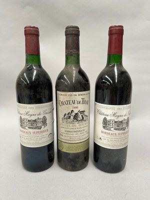 trois bouteilles de vin sont alignées sur une surface blanche