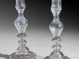 pair of clear glass candlesticks sitting on top of a white table