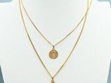 a gold necklace with two medallions on a mannequin