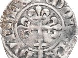 a close up of a silver coin with a cross on it