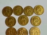 six types différents de pièces d'or sur une surface blanche
