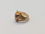 a close up of a gold ring with a lion head on it
