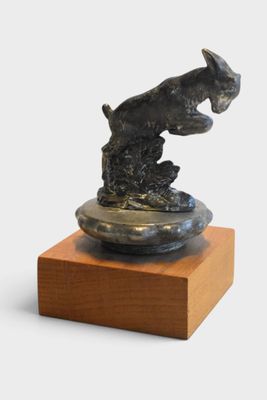 statue of a dog on a wooden base on a white background