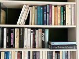 a book shelf with many books on it in a room