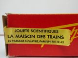 la boîte est ouverte sur une surface blanche sur laquelle est collé un autocollant