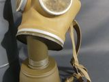 a gas mask that is sitting next to a bag