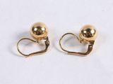 a pair of gold earrings on a white surface