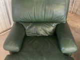 fauteuil inclinable en cuir vert avec un oreiller sur le dossier