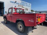 a red pick up truck parked in front of a building