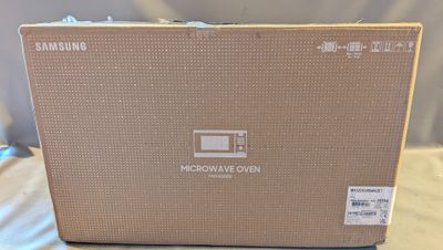 a samsung microwave oven in the box on the table