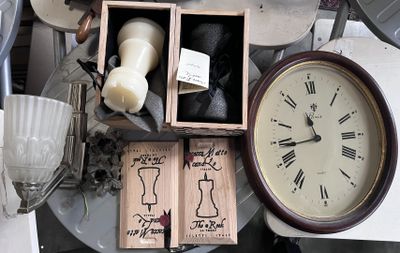 une table sur laquelle se trouvent une horloge, une bougie et d'autres objets