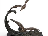 bronze sculpture of two seagulls flying over a wave on a black base