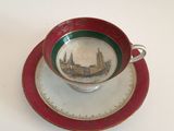 a cup and saucer with a picture of a city on it