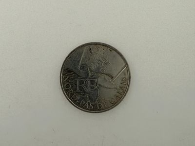 a small coin that is sitting on a white surface